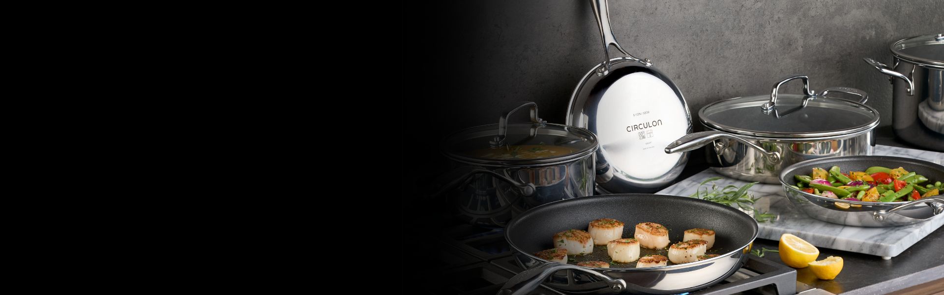 A person places a roasted turkey in a pan on a wooden board, surrounded by pots of vegetables on a dark table.