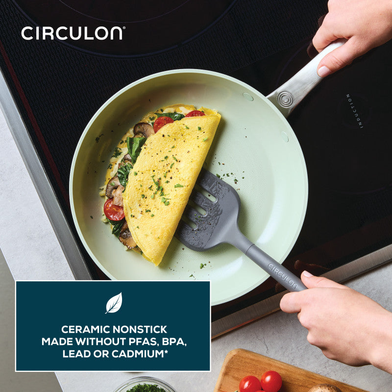 Person lifts omelette from Ceramic Nonstick 2-Piece Skillet Set with spatula.