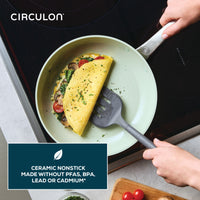 Person lifts omelette from Ceramic Nonstick 2-Piece Skillet Set with spatula.