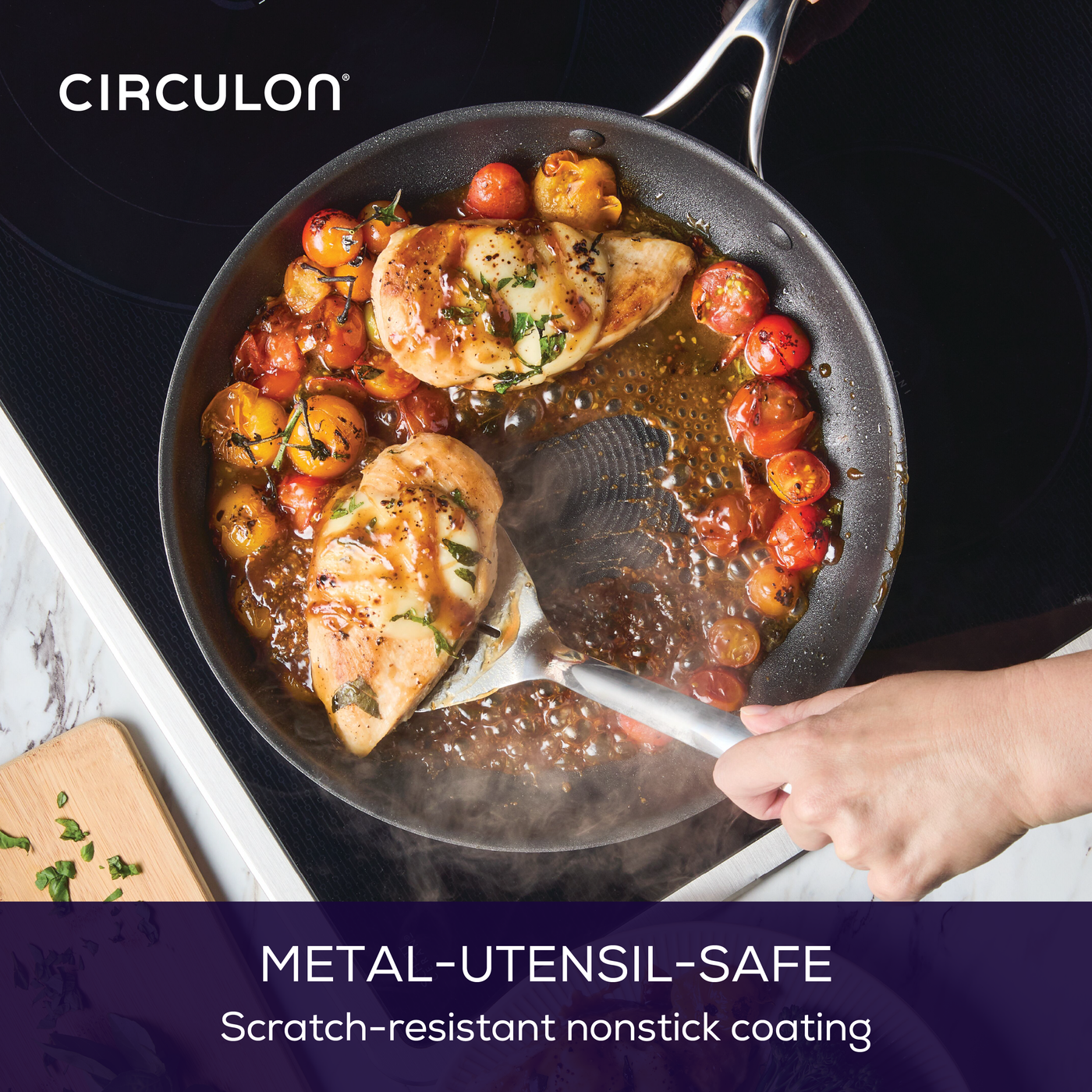 Hand cooking chicken and tomatoes in a nonstick frying pan on a stovetop.