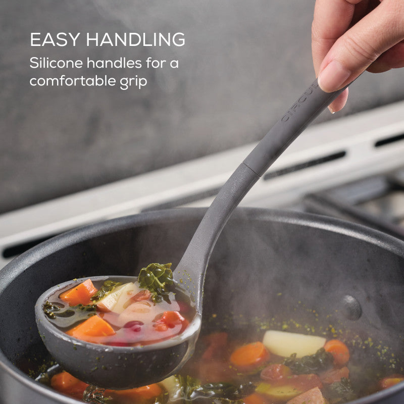 Hand serving vegetable soup with a ladle from the 4-Piece Silicone Tools Set.