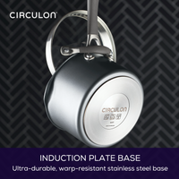 A shiny pot with an induction plate base hanging on a patterned background.
