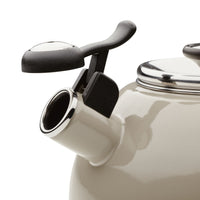 Close-up of a beige kettle spout with a black handle and silver accents.