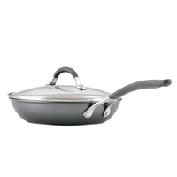 A nonstick frying pan with a glass lid and ergonomic handle.