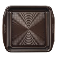 The 9-Inch Nonstick Square Cake Pan is crafted from durable steel and features a ridged surface along with integrated handles.