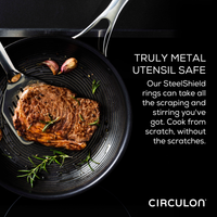 Steak sizzles in a pan with garlic and herbs, highlighting the importance of utensil safety. The 11-Piece Clad Stainless Steel and Hybrid Nonstick Cookware Set features revolutionary SteelShield technology, allowing your stainless steel utensils to glide effortlessly over nonstick surfaces, ensuring both durability and delicious results.