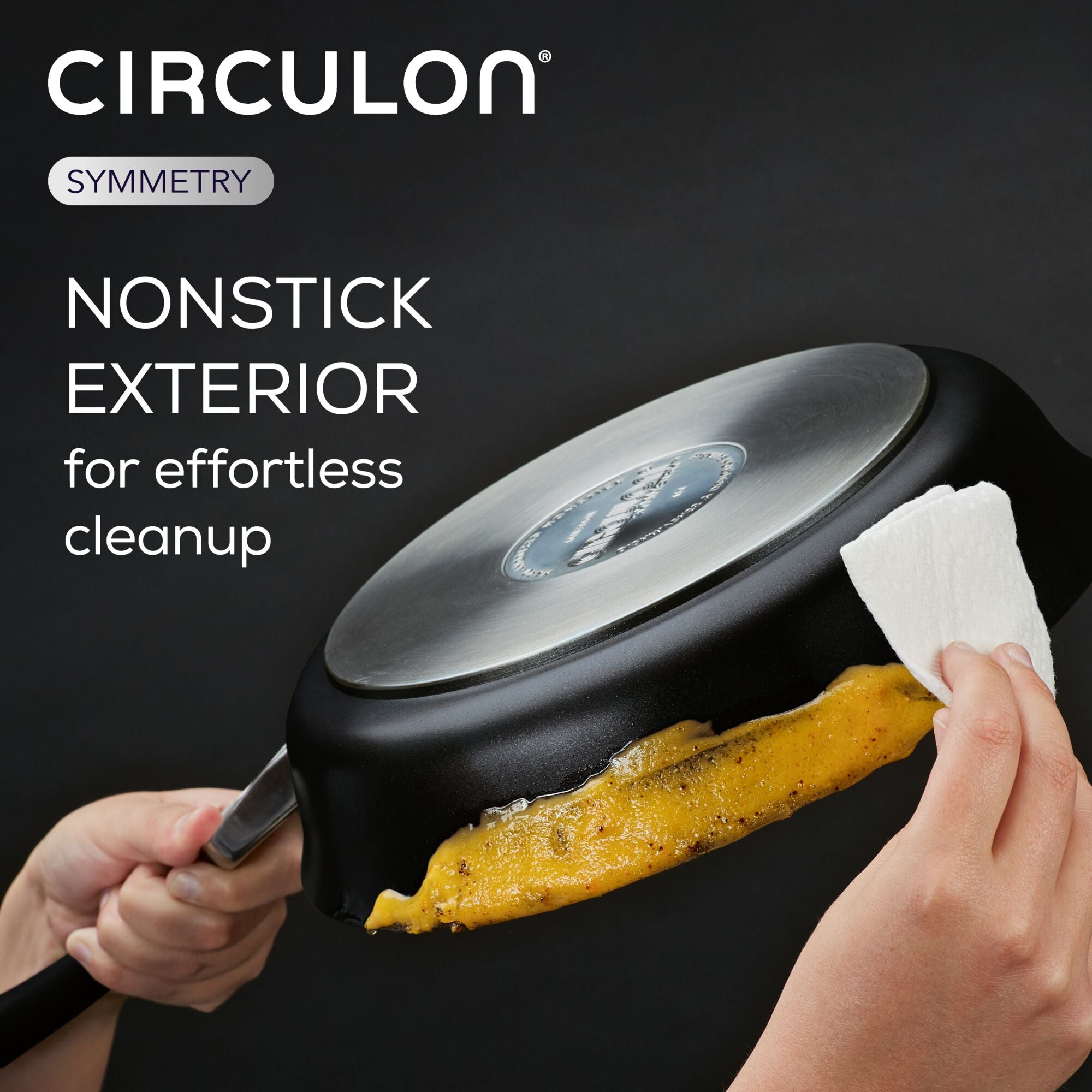 Using a paper towel, a person cleans food residue from the bottom of an 8.5-Inch Nonstick Frying Pan, ensuring it remains in excellent condition and ready for use on induction stovetops.