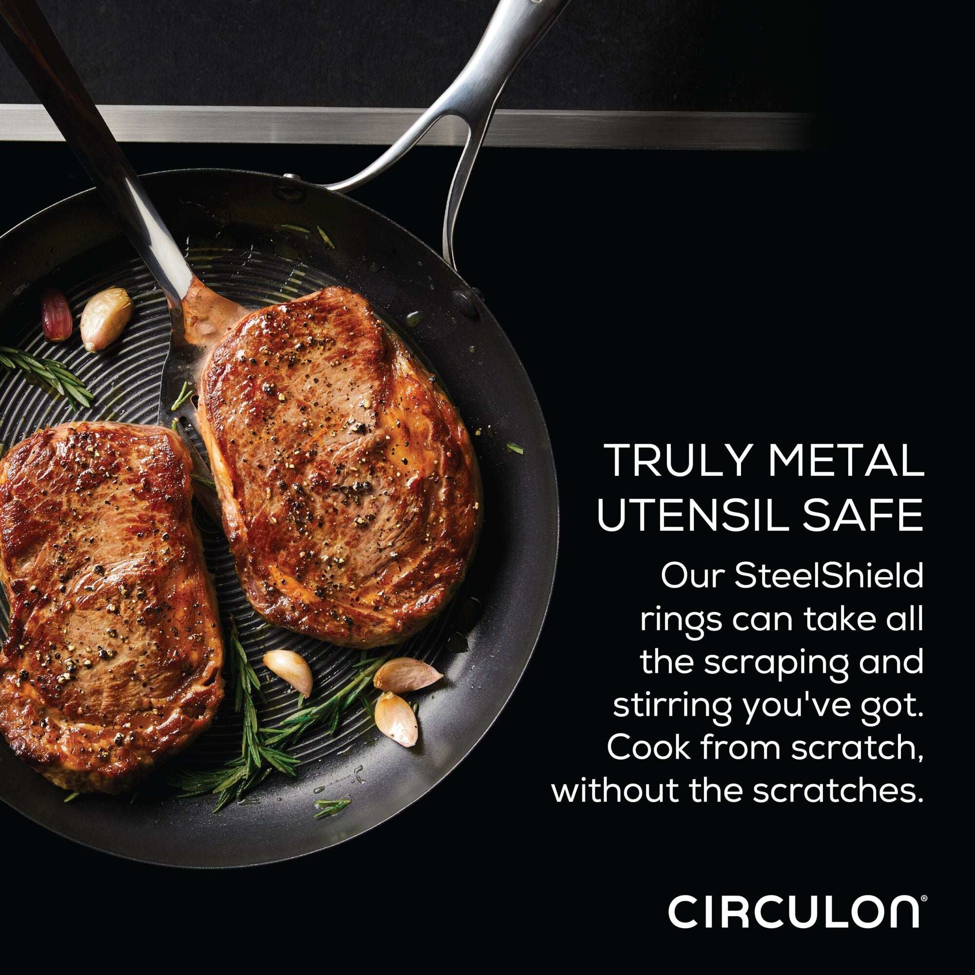 In an 8" Hybrid Stainless Steel Open Frying Pan that is induction-compatible, two pieces of steak sizzle, surrounded by fresh herbs and garlic.