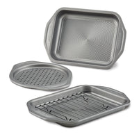 Introducing the 4-Piece Nonstick Toaster Oven Set: a collection of three gray baking trays, featuring a nonstick bake pan with a rack and a versatile roasting tray with holes, perfect for all your culinary needs.