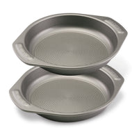 The 2-Piece 9-Inch Nonstick Cake Pan Set consists of two heavy gauge steel cake pans, each equipped with handles for easy maneuvering. The unique interiors of these baking pans guarantee flawless results every time.