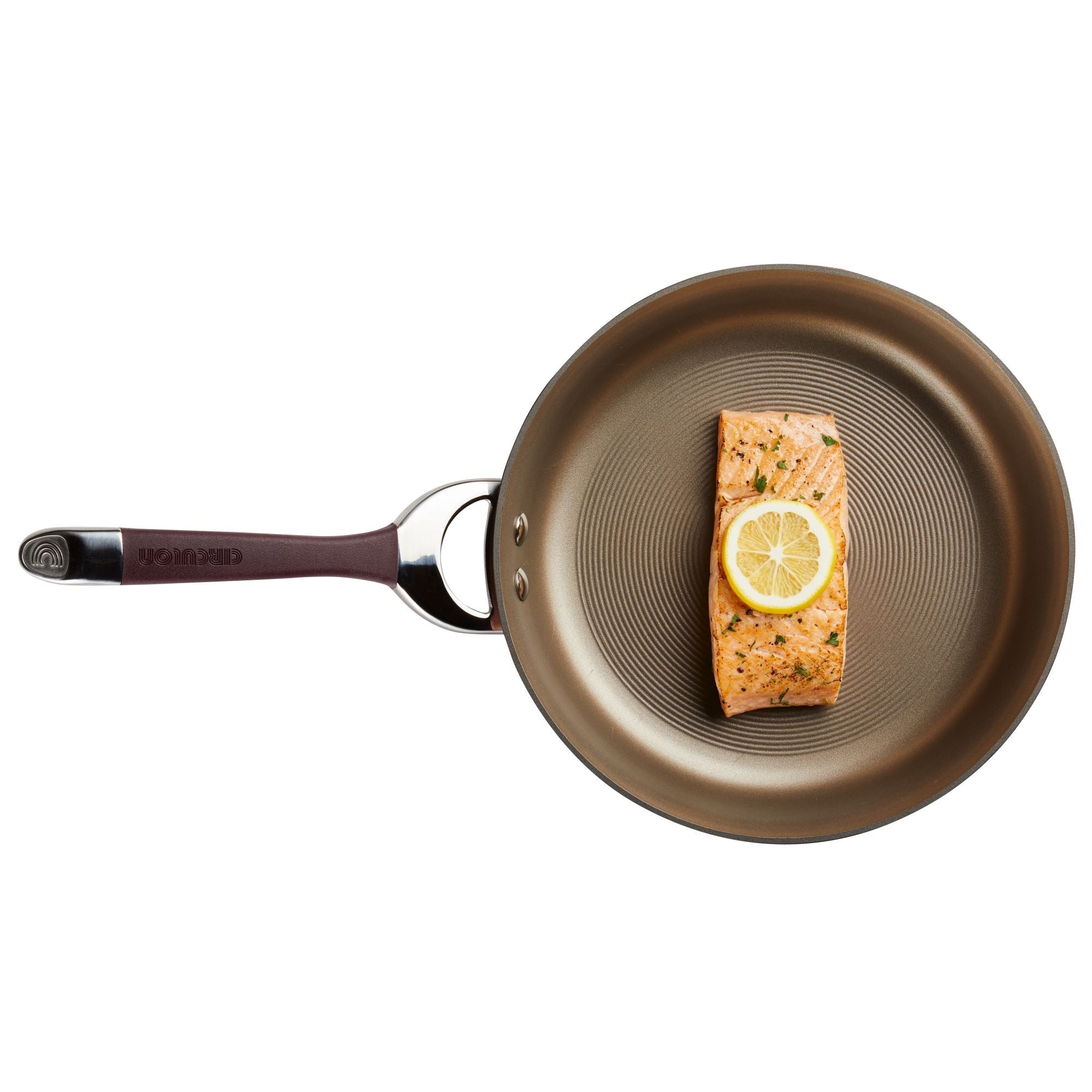 A salmon fillet with a lemon slice sizzles in a Hard-Anodized Frying Pan Set, renowned for its nonstick system, on a white background.