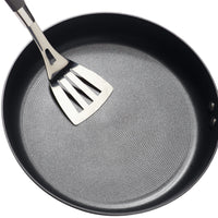 8.5-Inch Nonstick Frying Pan featuring a hard-anodized finish, designed for use on induction stovetops, complete with a metal spatula resting inside.