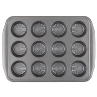 The 10-Piece Nonstick Bakeware Set includes a heavy gauge steel muffin baking tray with twelve circular molds, providing exceptional warp resistance and a nonstick surface for easy release.